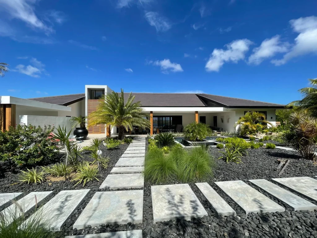 Moderne gelijkvloerse villa met strakke lijnen, tropische tuin en waterpartij, ontworpen door architect Almere met focus op luxe en buitenleven.