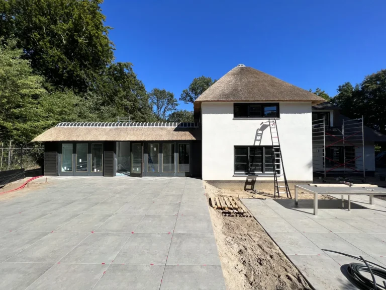 Terras met strakke bestrating aansluitend op een moderne woning