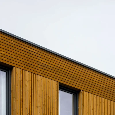 Detail uit het portfolio met houten gevelbekleding en strakke raamopeningen van een moderne woning.